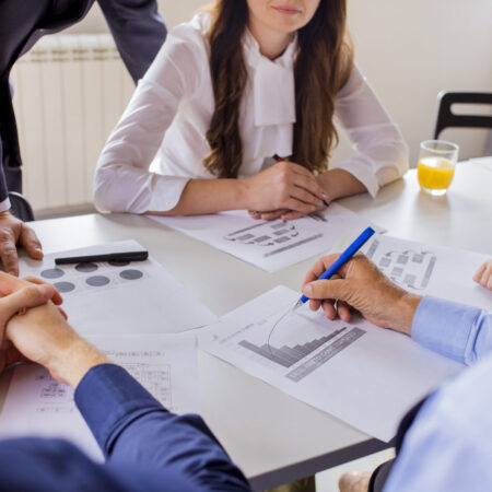 close-up-mature-businessman-analyzing-graph-with-his-colleagues close-up-mature-businessman-analyzing-graph-with-his-colleagues
